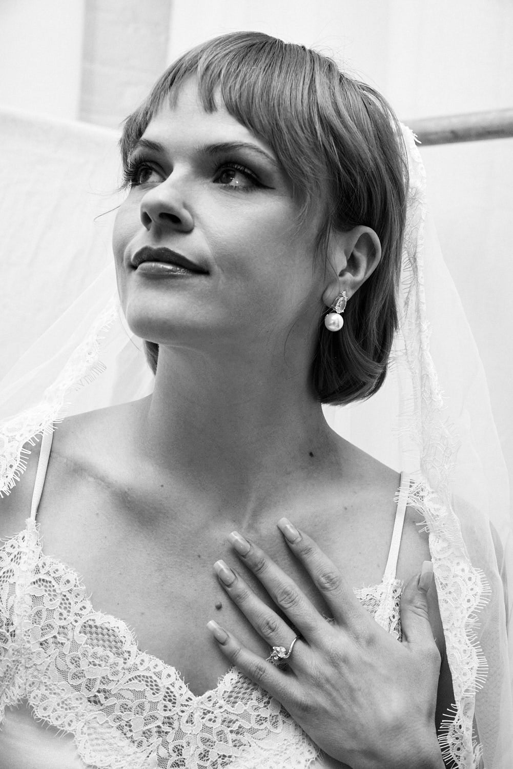 Black and white photo of a woman wearing a wedding dress with a veil with Bridal earrings.